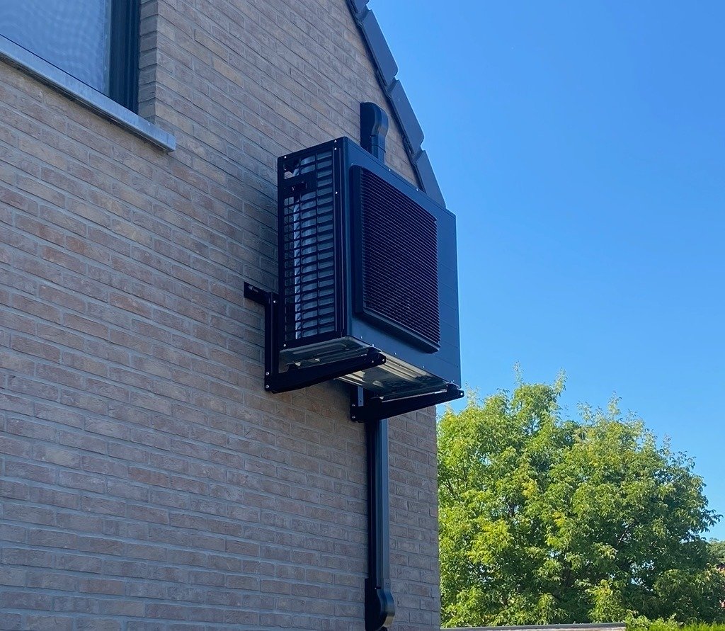 Buitenunit van een warmtepomp geïnstalleerd op gevel